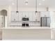 Bright kitchen boasts stainless appliances, pendant lighting, and an expansive center island with a sink at 14421 Nonna Sky Drive Dr, Spring Hill, FL 34609