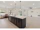 Open concept living area features kitchen with island, dining area and living room with ceiling fan at 14421 Nonna Sky Drive Dr, Spring Hill, FL 34609