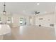 Open concept living area features kitchen with island, dining area and living room with ceiling fan at 14421 Nonna Sky Drive Dr, Spring Hill, FL 34609
