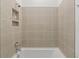 Shower-tub combination with tan ceramic tile and a built-in wall niche at 14421 Nonna Sky Drive Dr, Spring Hill, FL 34609