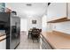 Functional kitchen featuring white cabinets, stainless steel appliances, and adjacent eat-in area at 1709 W Dempsey Ave, Tampa, FL 33603