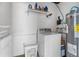 Functional laundry area with a washing machine, storage shelves, and essential utilities at 1709 W Dempsey Ave, Tampa, FL 33603