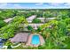 Aerial view of the community showing the pool, buildings, and lush, mature landscaping at 3038 Eastland Blvd # F103, Clearwater, FL 33761