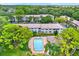 Aerial view of the outdoor pool and building with sundeck surrounded by green landscaping at 3038 Eastland Blvd # F103, Clearwater, FL 33761