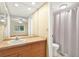 Bright bathroom with a large mirror, sink, and shower with curtain at 3038 Eastland Blvd # F103, Clearwater, FL 33761