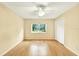 A naturally lit bedroom has hardwood floors and a ceiling fan for air circulation at 3038 Eastland Blvd # F103, Clearwater, FL 33761
