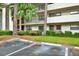 Condominium exterior and covered parking with meticulous landscaping, and building facade at 3038 Eastland Blvd # F103, Clearwater, FL 33761