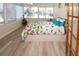Light filled bedroom boasts wood-look floors and large windows overlooking a serene outdoor area at 3526 Overland Dr, Holiday, FL 34691