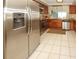 Well-lit kitchen with stainless steel appliances, wooden cabinets, and white tiled floor at 3526 Overland Dr, Holiday, FL 34691
