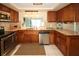 Well-maintained kitchen featuring stainless steel appliances, wood cabinetry, and neutral countertops at 3526 Overland Dr, Holiday, FL 34691