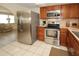 This is a nice kitchen featuring stainless steel appliances, wood cabinets and easy access to other rooms at 3526 Overland Dr, Holiday, FL 34691