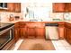 This kitchen has wood cabinets, stainless steel appliances, white tile floors and backyard views at 3526 Overland Dr, Holiday, FL 34691