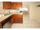 Kitchen boasts wood cabinets, white tile floors and easy access to other rooms of the house at 3526 Overland Dr, Holiday, FL 34691