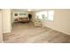 Spacious living room featuring wood-look flooring, large windows, and neutral walls at 3526 Overland Dr, Holiday, FL 34691