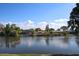 Scenic view of a serene lake surrounded by lush greenery and charming waterfront homes under a blue sky at 3526 Overland Dr, Holiday, FL 34691
