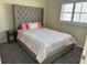 Bedroom with a tufted headboard, neutral carpet and a window with blinds at 4115 Corn St, Port Charlotte, FL 33948