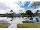 Wooden dock on the waterfront with chairs and a table, perfect for relaxing and enjoying the view at 4115 Corn St, Port Charlotte, FL 33948