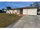 Charming single-story home with a well-maintained lawn and a paved driveway leading to an attached two-car garage at 4115 Corn St, Port Charlotte, FL 33948