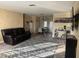 Cozy living room adjacent to dining area features a modern rug and comfortable leather seating at 4115 Corn St, Port Charlotte, FL 33948