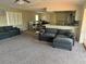 Comfortable living room with plush seating and carpet, adjoins an open concept dining and kitchen area at 4115 Corn St, Port Charlotte, FL 33948