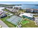 Aerial view of community amenities: tennis courts, putting green, pool, and building exteriors at 4620 Bay Blvd # 1154, Port Richey, FL 34668