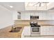 Updated kitchen featuring granite countertops, white cabinetry, stainless steel appliances, and a skylight at 4620 Bay Blvd # 1154, Port Richey, FL 34668