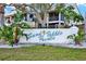 Community sign reads 'Sand Pebble Pointe' with tropical plants in front of the building at 4620 Bay Blvd # 1154, Port Richey, FL 34668