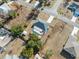 Aerial view showcasing a pool and screen, mature trees, and fenced yard at 5155 Baldock Ave, Spring Hill, FL 34608