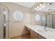 Well-lit bathroom featuring a glass shower, a large mirror, and a unique octagonal window at 5155 Baldock Ave, Spring Hill, FL 34608