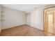 Neutral-colored bedroom has wood floors and a closet with folding doors near the entry to the hallway at 5155 Baldock Ave, Spring Hill, FL 34608