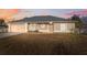 Tan single-story home with a garage, neutral trim, and well-maintained gray roof at 5155 Baldock Ave, Spring Hill, FL 34608