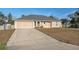 Single-story tan home with attached garage, long driveway and xeriscaped front yard at 5155 Baldock Ave, Spring Hill, FL 34608