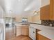 Bright kitchen featuring white appliances and a breakfast bar overlooking the living area at 5155 Baldock Ave, Spring Hill, FL 34608