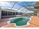 Backyard boasts a screened-in pool with ample deck space for outdoor lounging and entertaining at 5155 Baldock Ave, Spring Hill, FL 34608
