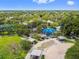 Aerial view features a park with a blue playground, picnic pavilions, lush greenery, and walking paths in a sunny neighborhood at 5640 Ferguson Ct # 2208, New Port Richey, FL 34652