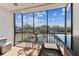 Enclosed balcony featuring tile flooring, a seating area, and panoramic waterfront views at 5640 Ferguson Ct # 2208, New Port Richey, FL 34652