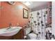 Cozy bathroom features unique palm-themed shower curtain and peach colored walls at 5640 Ferguson Ct # 2208, New Port Richey, FL 34652