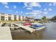 Community boat dock featuring several covered boats, waterfront access and direct access to building residences at 5640 Ferguson Ct # 2208, New Port Richey, FL 34652