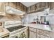 Bright kitchen with unique wood-patterned cabinets and a white range at 5640 Ferguson Ct # 2208, New Port Richey, FL 34652