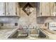 Kitchen featuring a stainless-steel sink and mosaic backsplash at 5640 Ferguson Ct # 2208, New Port Richey, FL 34652