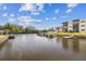 A waterfront view featuring condos with private boat docks on a sunny day with blue skies at 5640 Ferguson Ct # 2208, New Port Richey, FL 34652