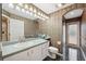 Bathroom with a toilet, vanity, shower, and leaf-patterned wallpaper at 6112 Kinlock Ave, Spring Hill, FL 34608