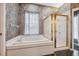 Bathroom featuring a soaking tub, a gold-trimmed shower, and floral wallpaper at 6112 Kinlock Ave, Spring Hill, FL 34608