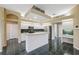 Well-lit kitchen with white cabinetry, a center island, and black tiled floors. Perfect for cooking! at 6112 Kinlock Ave, Spring Hill, FL 34608