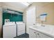 Laundry room with a washer, dryer, utility sink, and storage shelves at 6112 Kinlock Ave, Spring Hill, FL 34608