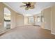 Spacious living room with neutral walls and carpet and views of the home's entrance and kitchen at 6112 Kinlock Ave, Spring Hill, FL 34608