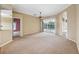 Spacious living room with neutral walls, carpet, and a large sliding glass door leading to a pool at 6112 Kinlock Ave, Spring Hill, FL 34608