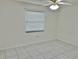 Bedroom features a window with blinds and ceiling fan at 6401 Drexel Dr # 1, Port Richey, FL 34668