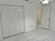 Bedroom with double door closet and tile floors at 6401 Drexel Dr # 1, Port Richey, FL 34668