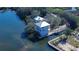 Aerial of a three-story waterfront home with boat dock, surrounded by lush trees and canals at 6801 Nowiki Ave, Hudson, FL 34667